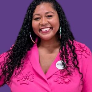 Headshot of Candace Avalos (with brown skin, long curly black hair, and pink blazer jacket)