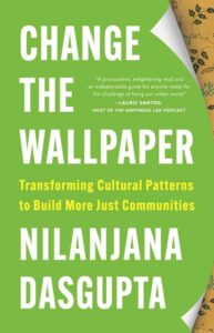 Book cover for "Change the Wallpaper" by Nilanjana Dasgupta. The title is listed in bold text with the subtitle underneath in small yellow text: "Transforming Cultural Patterns to Build More Just Communities." The background is a plain green with peeling corners showing a yellow floral wallpaper.