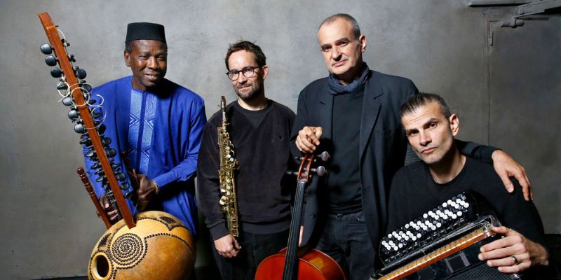 4 Musicians face the camera holding their respective instruments