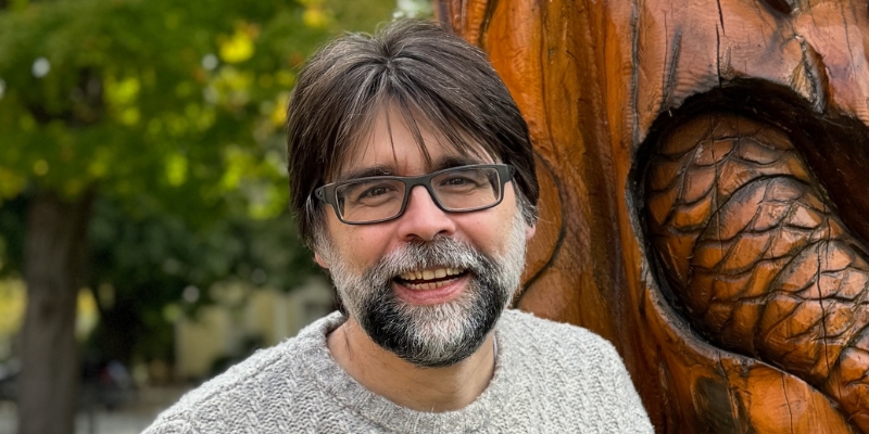 Outdoor headshot of Joe Hill (with short dark hair, black/grey beard, and eyeglasses)