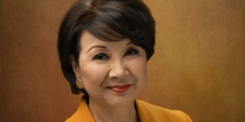 Headshot of Lori Matsukawa (with light skin and short black hair, wearing a yellow blazer)