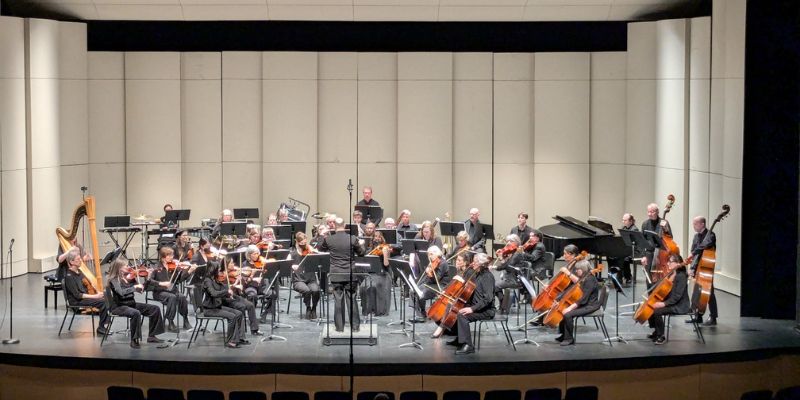Philharmonia NW Orchestra on stage in a large auditorium