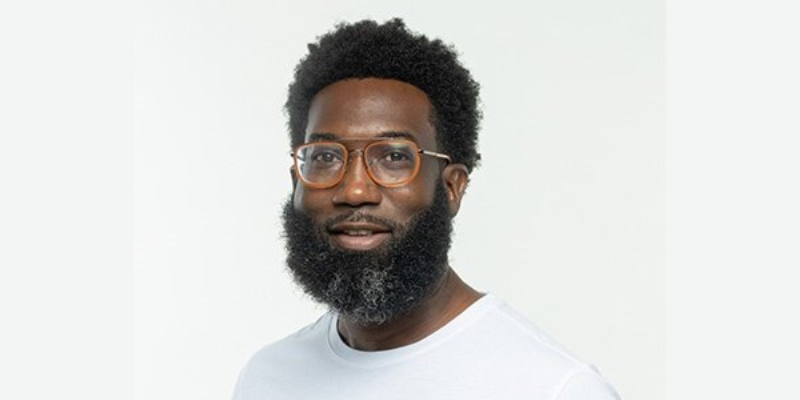 Shamichael Hallman wearing a white tee with bicycles and orange glasses