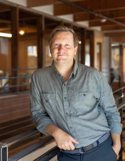 Chef John Sundstrom in a blue shirt, leaning against a railing.