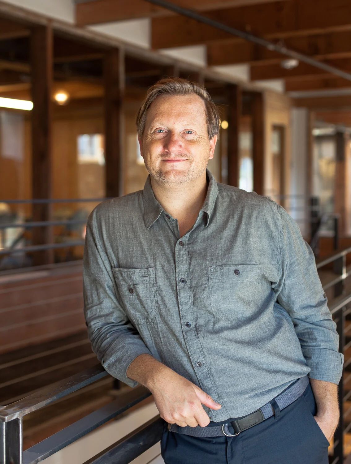 Chef John Sundstrom in a blue shirt, leaning against a railing.